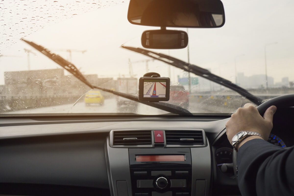 business man is driving car raining day with moving wiper blades